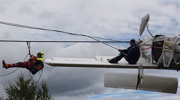 Uçak elektrik tellerinde asılı kaldı, pilot kanada oturup kurtarılmayı bekledi
